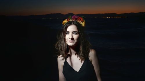 Portrait of smiling young woman by sea against sky