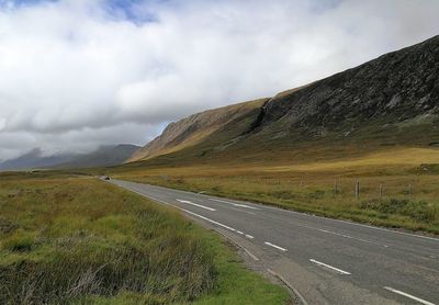 Road by mountain against sky