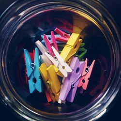 Directly above shot of multi colored clothespins in glass container