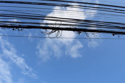 Low angle view of power lines against blue sky