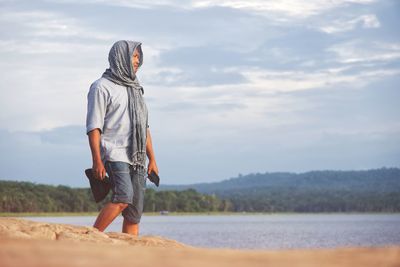 Man standing at beach against sky