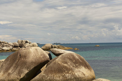 Rocks on beach against sky