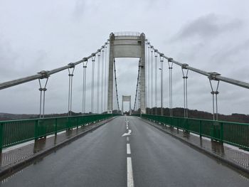 View of suspension bridge against cloudy sky