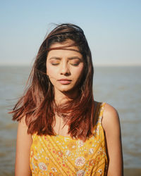 Portrait of young woman against sea