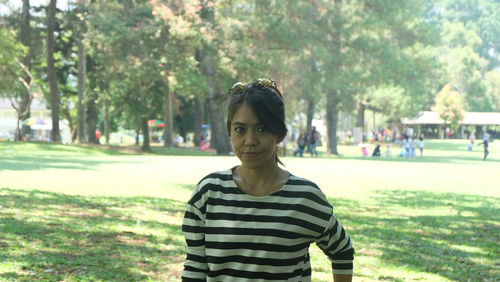 Portrait of young woman standing in park
