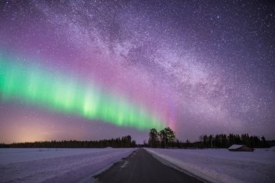 Snow covered road against sky at night