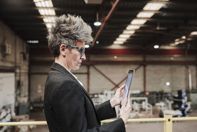 Mature businesswoman using tablet pc at factory