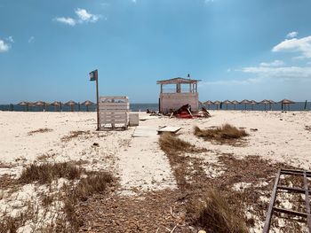 Lifeguard hut on beach against sky