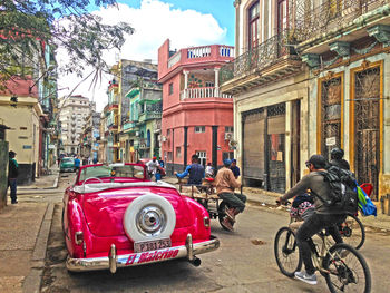 People on street against buildings in city