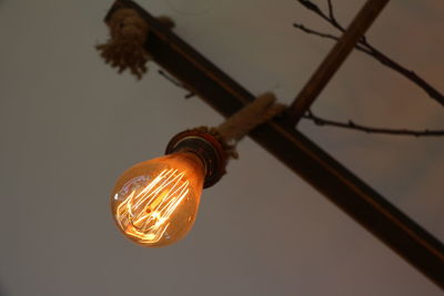 Low angle view of illuminated light bulb against sky at dusk