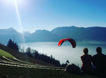 People on mountain against clear sky