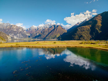 Scenic view of lake and mountains against blue sky