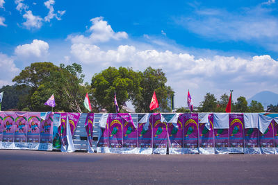 Graffiti on wall by road against blue sky