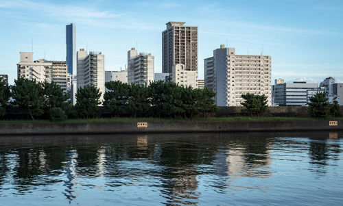 Scenic view of lake by buildings against sky