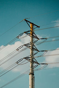 Low angle view of electricity pylon against sky