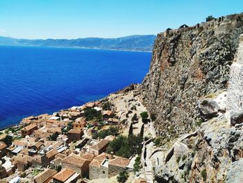 Aerial view of townscape by sea against clear sky