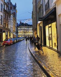 People walking on street amidst buildings in city