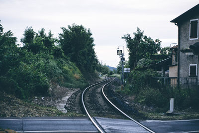 Railroad tracks passing through road against clear sky