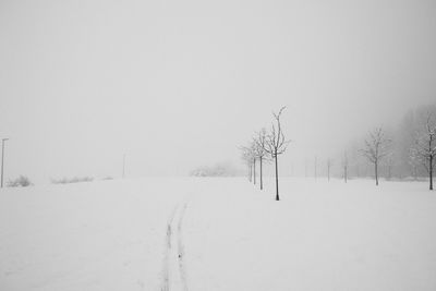 Snow covered field against clear sky