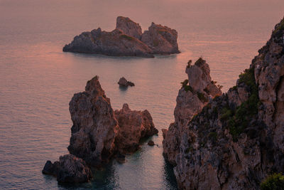 High angle view of rock formations and sea during sunset