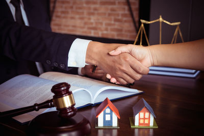 Close-up of hands holding book on table