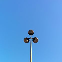 Low angle view of street light against clear blue sky