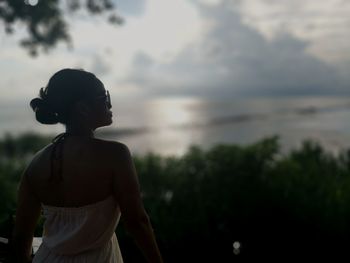 Woman standing against sky during sunset