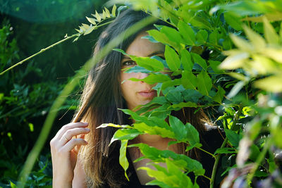 Portrait of young woman with palm leaves