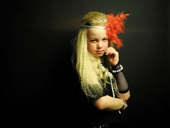 Portrait of girl wearing headdress against black background