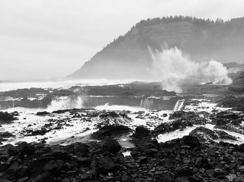 Panoramic shot of rocks on beach against sky