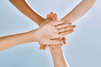 Cropped hand of woman holding hands against blue background