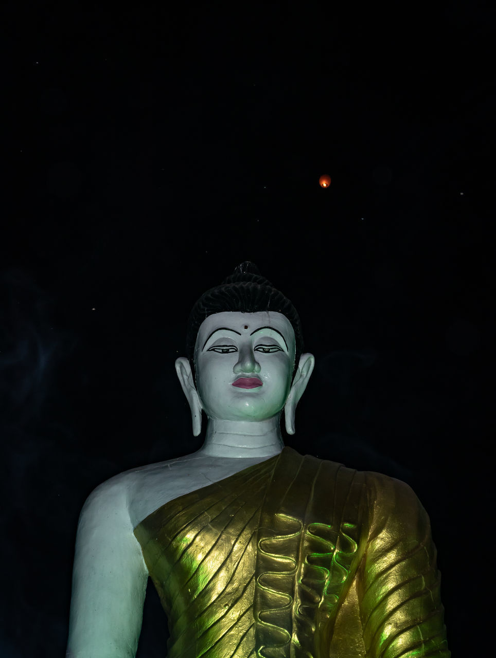 LOW ANGLE VIEW OF STATUE OF BUDDHA AGAINST BLACK BACKGROUND