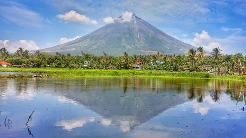 Scenic view of lake and mountains against blue sky