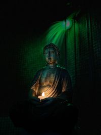 Statue of buddha against dark background