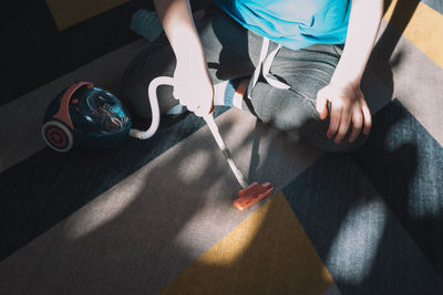 Boy vacuuming the carpet with a toy vacuum cleaner. child development concept