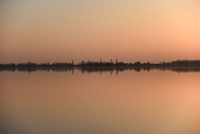 Scenic view of lake against orange sky