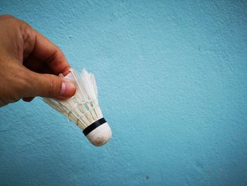 Close-up of hand holding blue wall