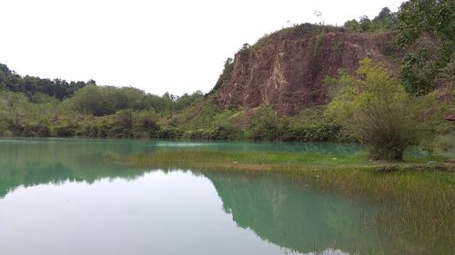 Scenic view of lake by trees against clear sky