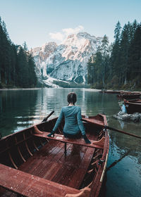 Rear view of woman on boat in lake against sky