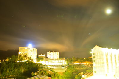 Illuminated cityscape against sky at night