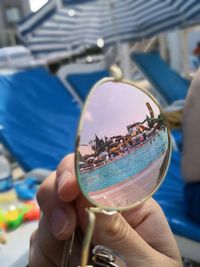 Cropped hand of person holding sunglasses at water park