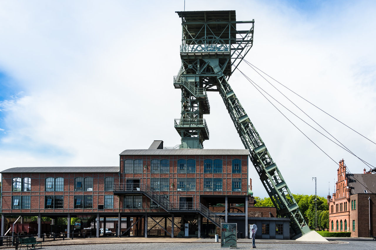 architecture, built structure, building exterior, low angle view, tower, sky, crane - construction machinery, development, tall - high, city, cloud, outdoors, day, office building, tall, growth, construction, building story, city life, skyscraper, progress, no people, contrasts, construction equipment