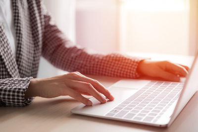 Midsection of woman using laptop