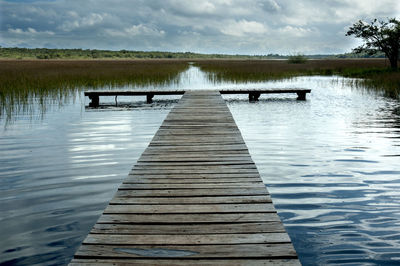 Pier over lake against sky