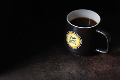 High angle view of coffee cup against black background