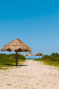 Built structure on beach against clear blue sky