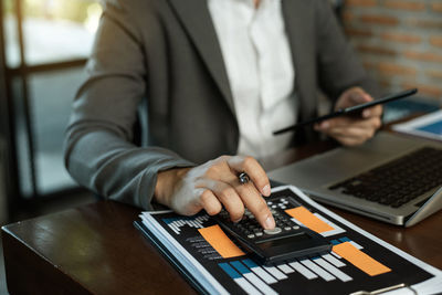 Midsection of man using mobile phone