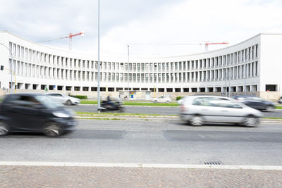 Traffic on road in city against sky