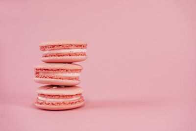 Macaroons are delicious french cookies. pink macaroons on pink background. copy space.