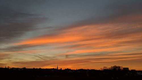 Silhouette buildings against sky during sunset